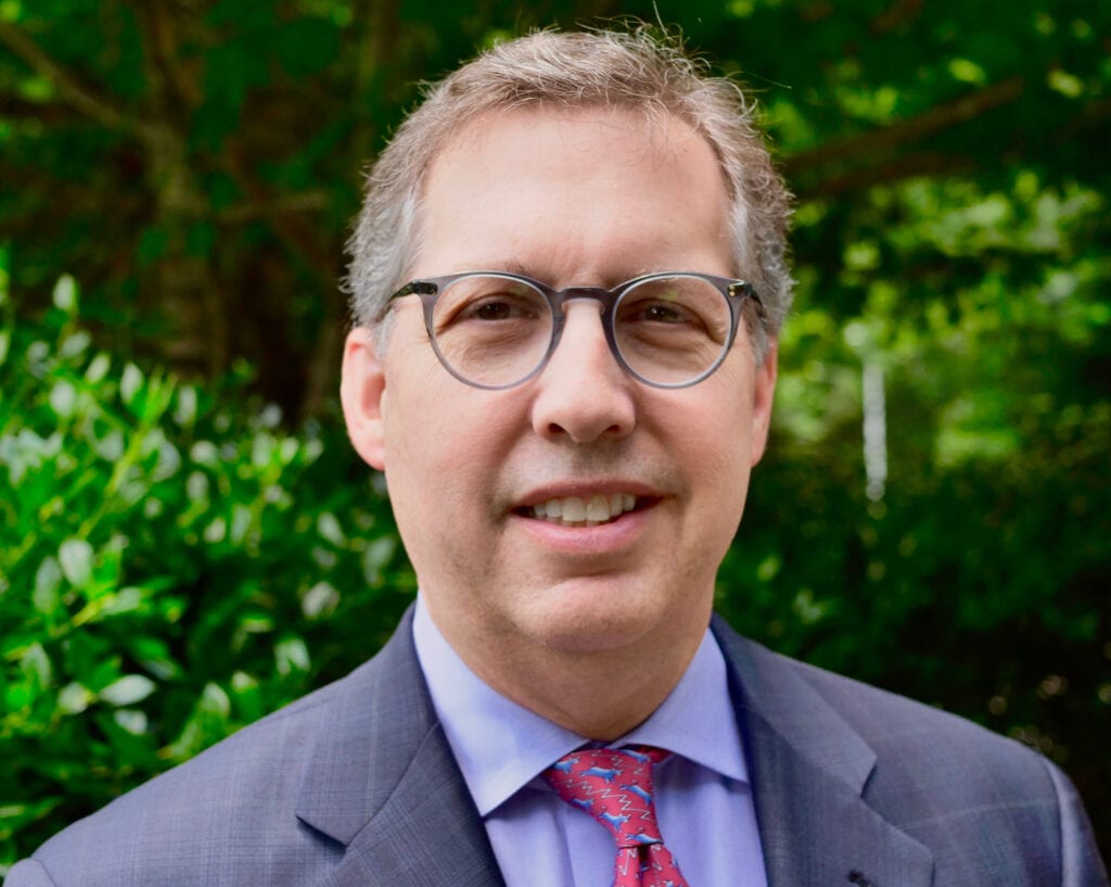 A man in a suit and tie standing outside.