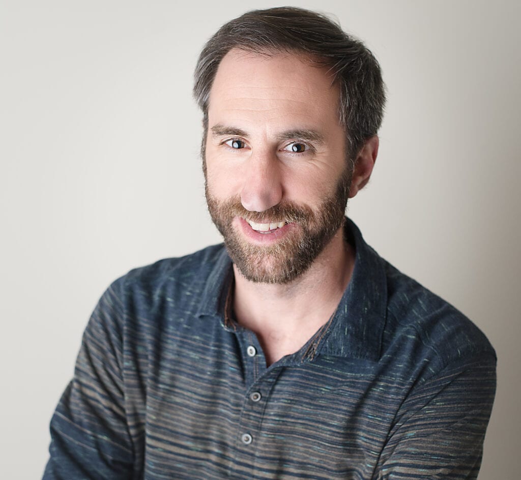 A man with beard and smiling at the camera.